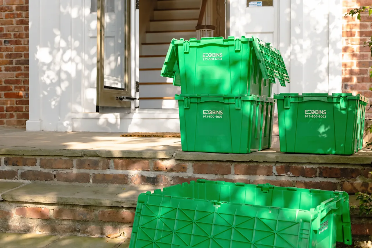 Green EcoBins arranged outside a building entrance beside the steps