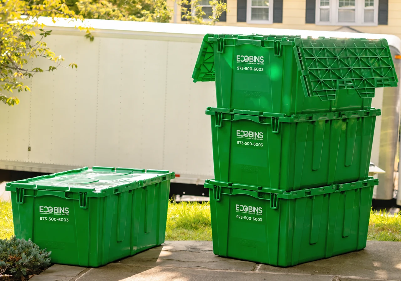Actual green EcoBins stacked beside a closed bin, with attached hinged lids and the phone number 973-500-6003